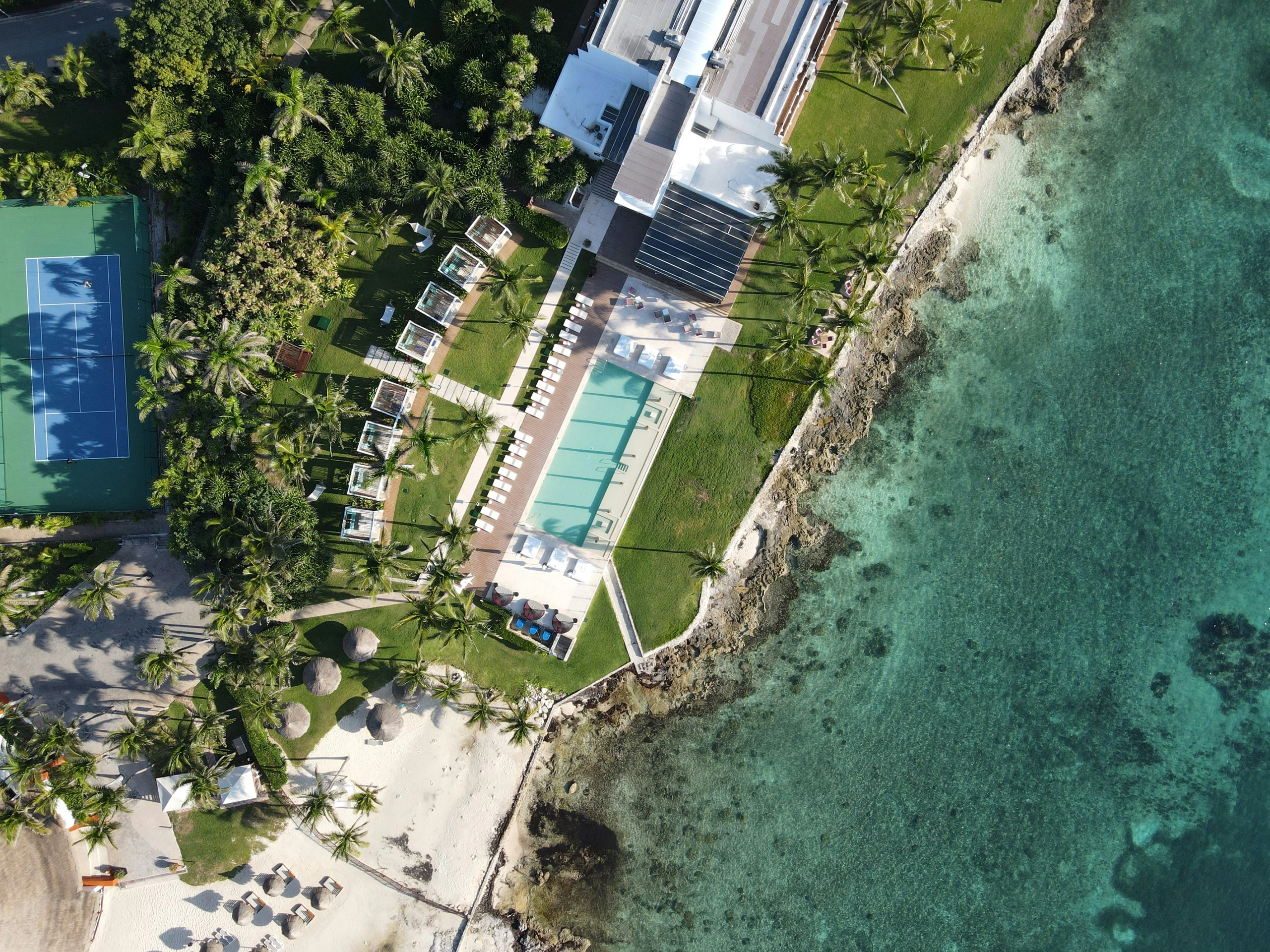 Drone photograph of a beachfront resort above turquoise water