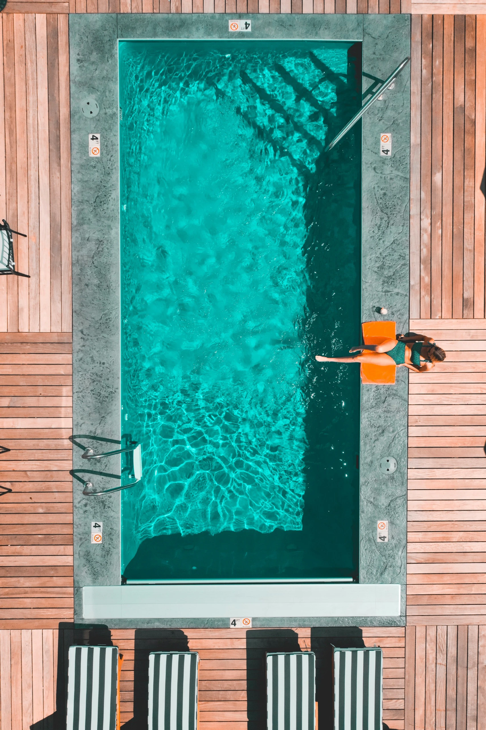 Overhead drone photograph of a hotel pool and timber deck